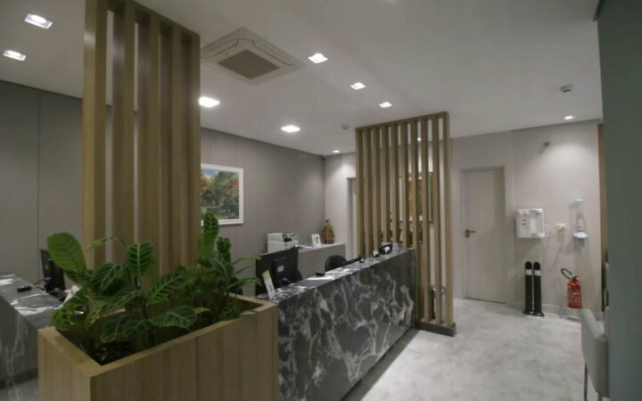 Sala de atendimento do consultório de oftalmologia, com equipamento de exame e poltrona do paciente